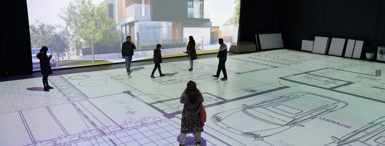 People walking through a projected floor plan at full 1:1 scale